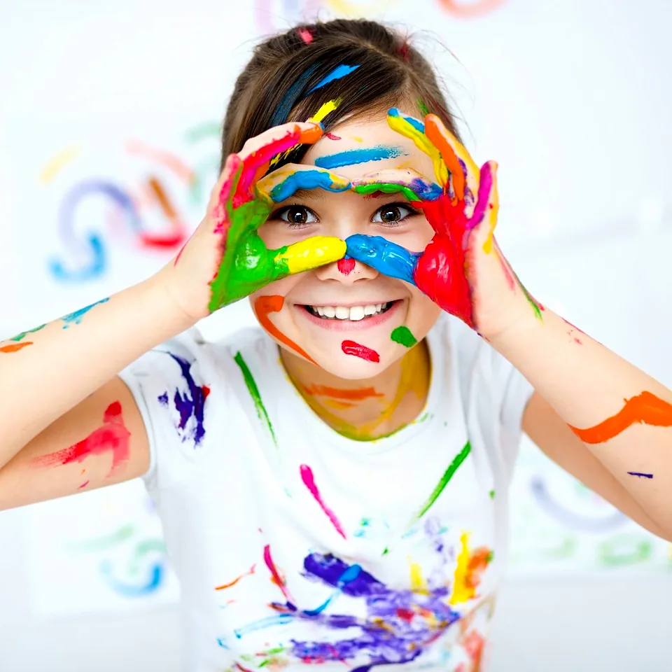 Smiling child with colorful painted hands