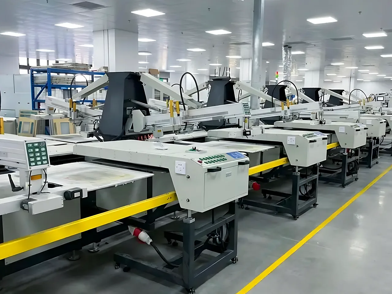 CLT SM60-85 oval garment printing machines with yellow rails in a factory hall